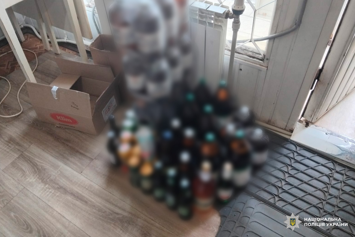 У приміщенні зберігаються великі пластикові бутлі квасу та інші напої, розташовані біля дверей і радіатора.