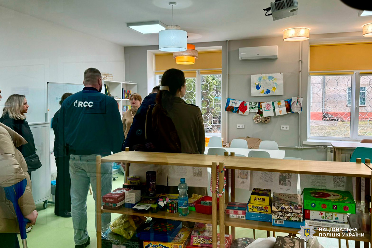 Освітній простір із книгами, дитячими малюнками та настільними іграми, де присутні учасники програми.