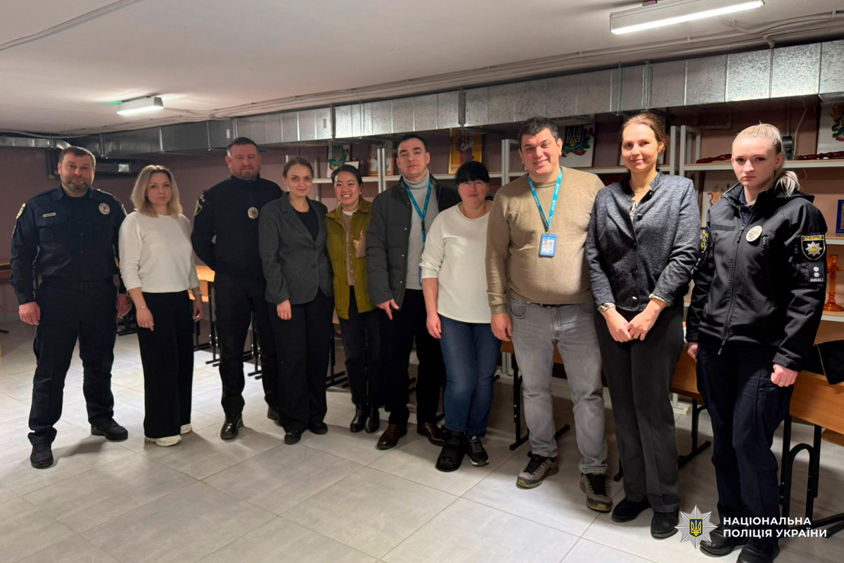 Правоохоронці та представники громади стоять разом у службовому приміщенні.