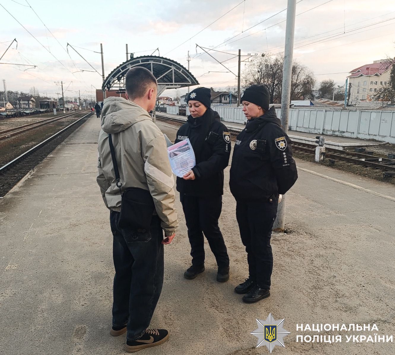 На фотографії зображено поліцейських Київщини, які проводять профілактичні заходи з підлітками на залізниці.
