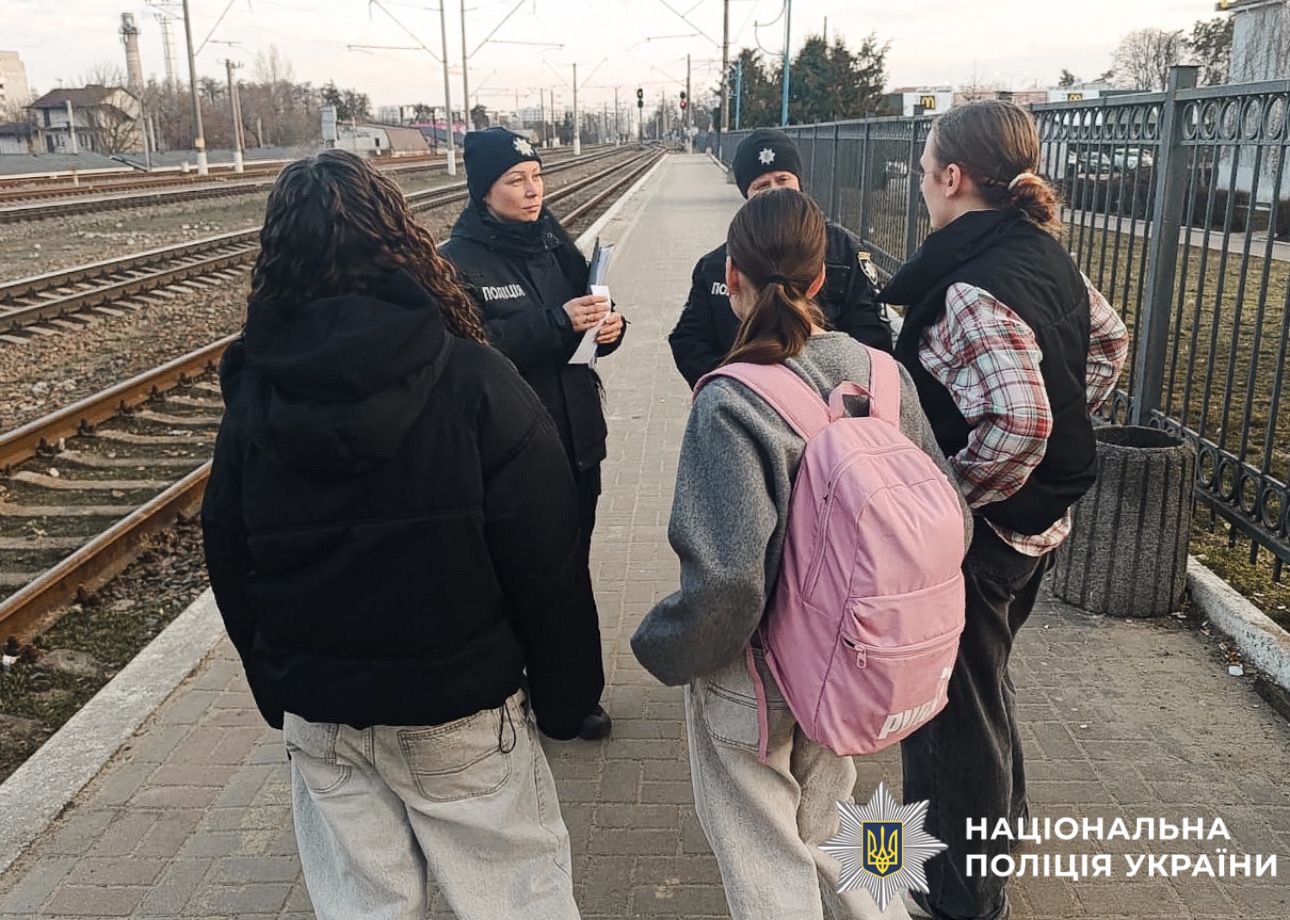 На фотографії зображено поліцейських Київщини, які проводять профілактичні заходи з підлітками на залізниці.