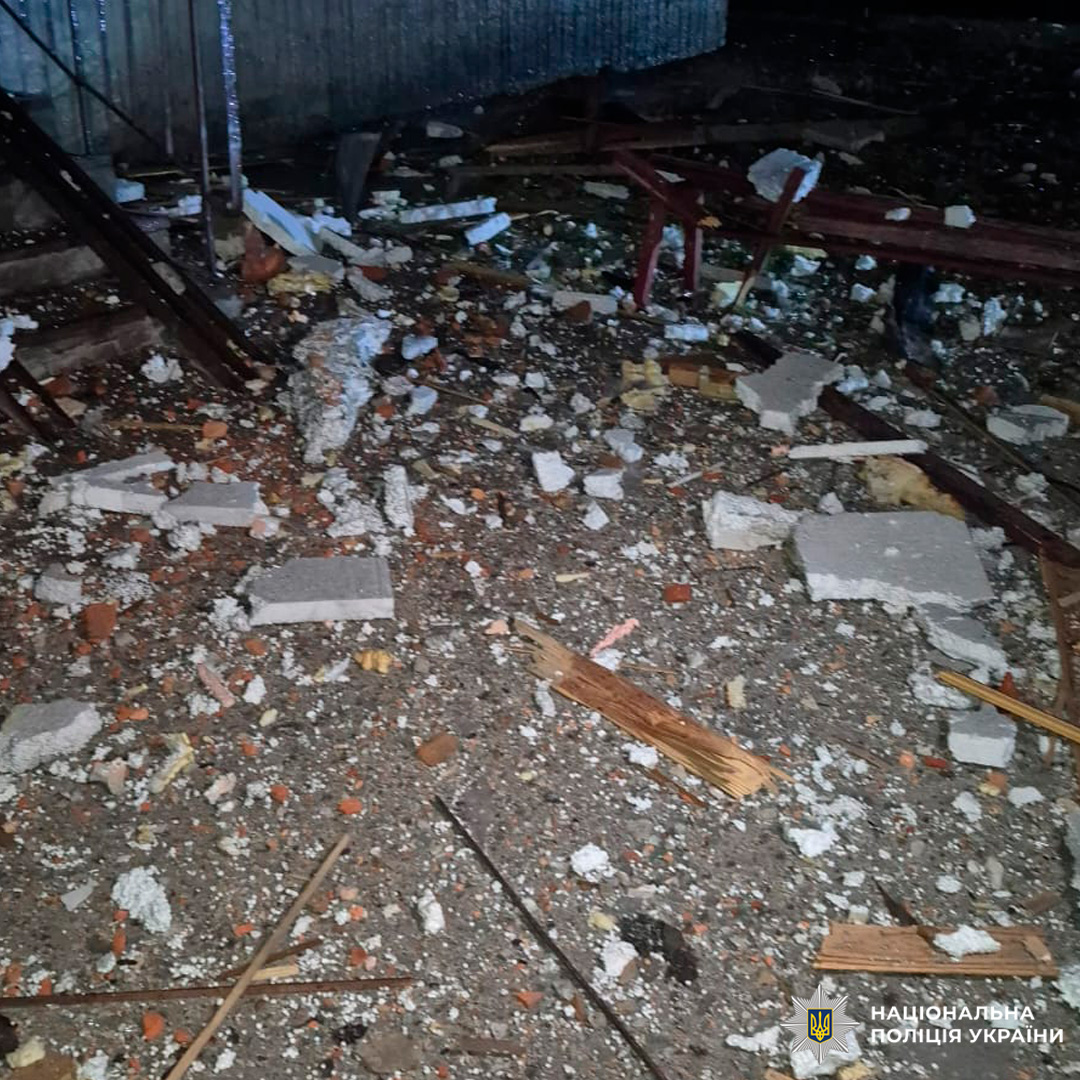 Руйнування будівлі: уламки цегли, бетону та дерева розкидані на землі, металеві сходи та стіна з профнастилу на тлі.