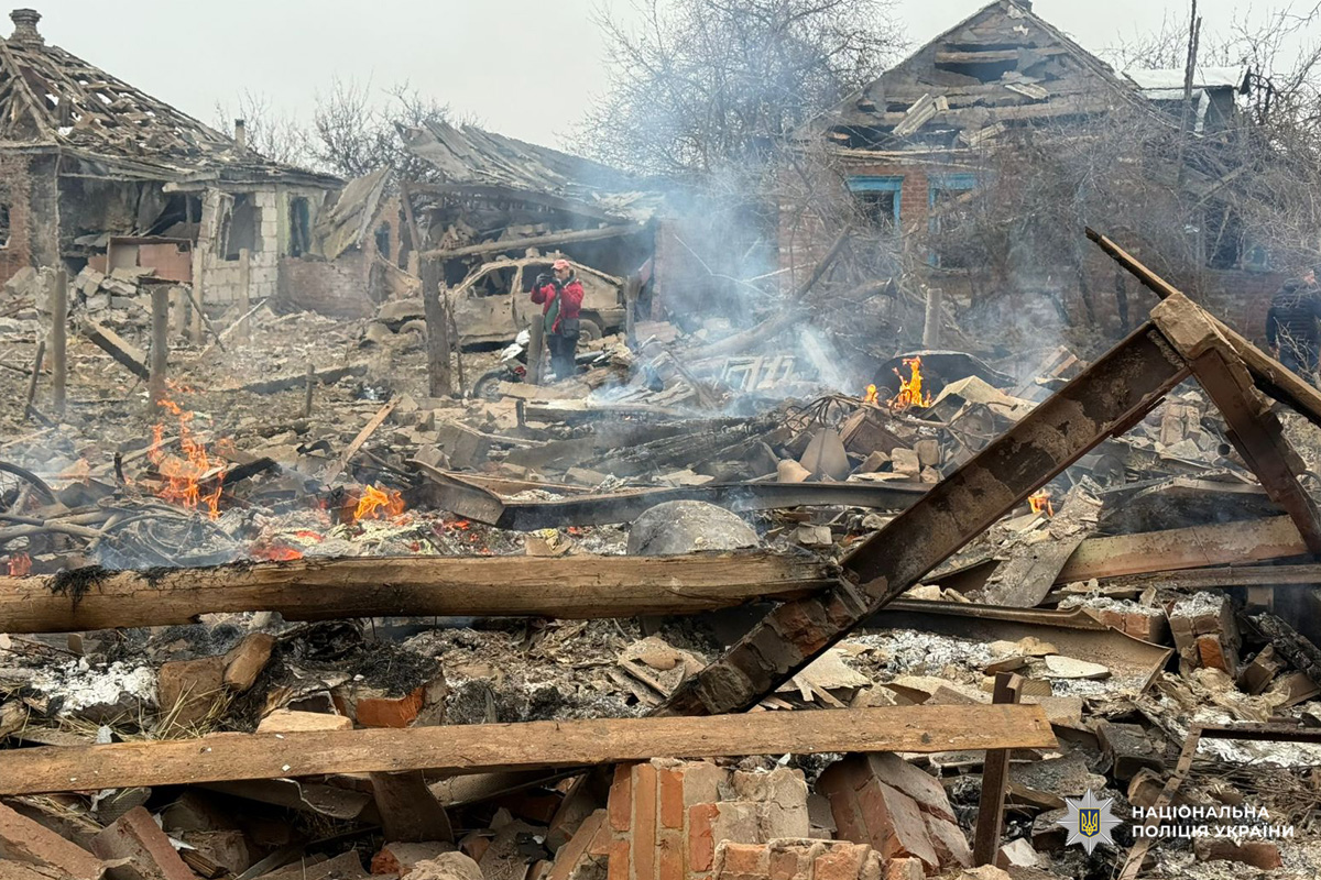 Зруйновані житлові будинки після обстрілу: уламки деревини, цегли й металу, осередки пожежі та дим.