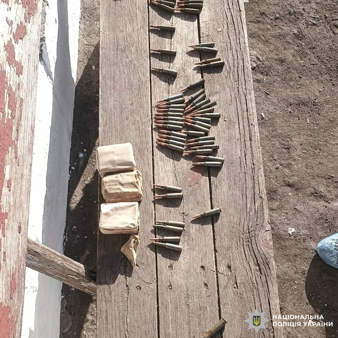 На старій лавці просто неба лежать патрони військового зразка та паперові пакунки з боєприпасами.