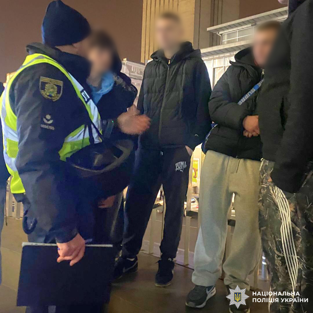 Офіцер поліції спілкується з молоддю на вулиці.