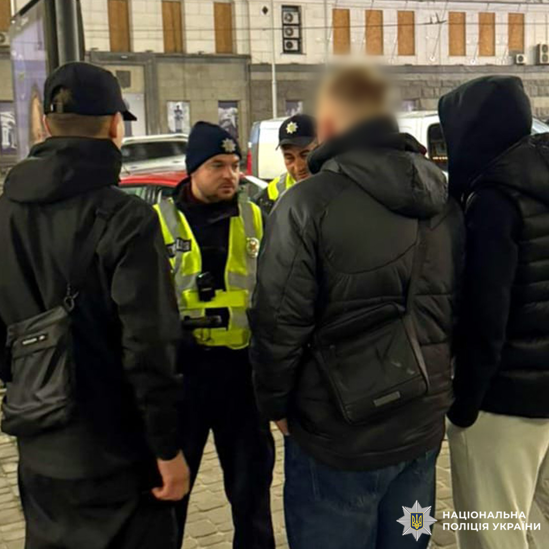 Офіцер поліції спілкується з молоддю на вулиці.