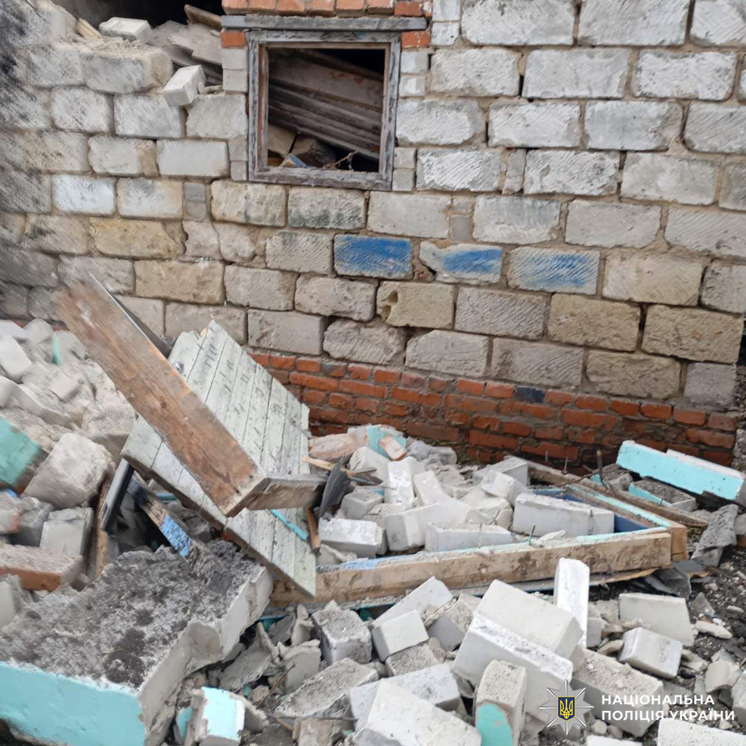 Зруйнована стіна з цегли та блоків, уламки на землі.