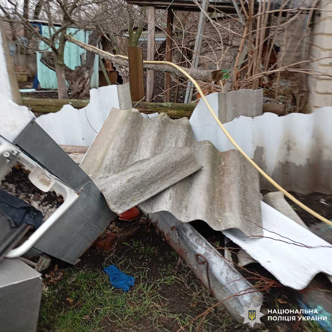 Пошкоджене подвір’я з уламками та даховими листами.