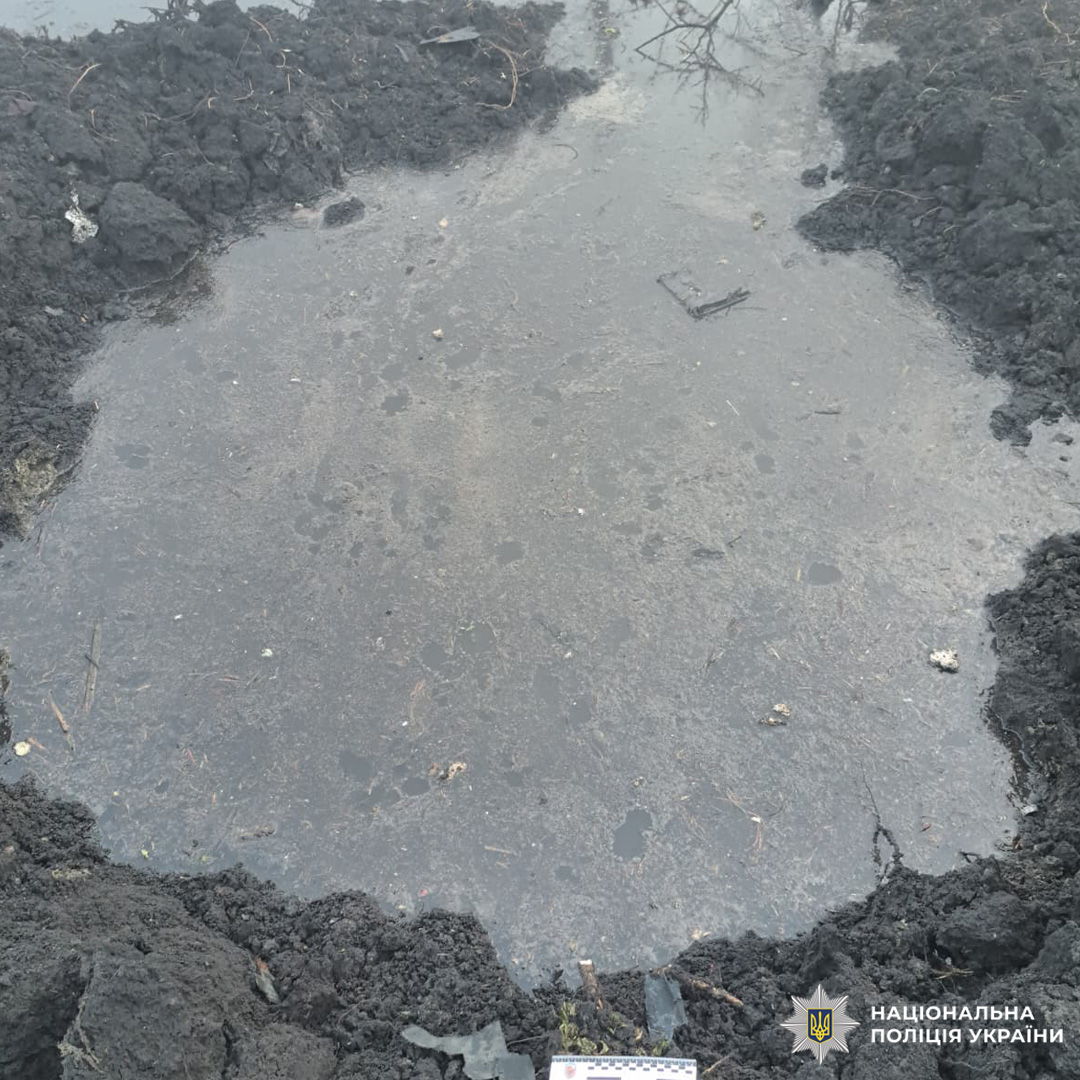 Вирва, заповнена водою, з уламками навколо.