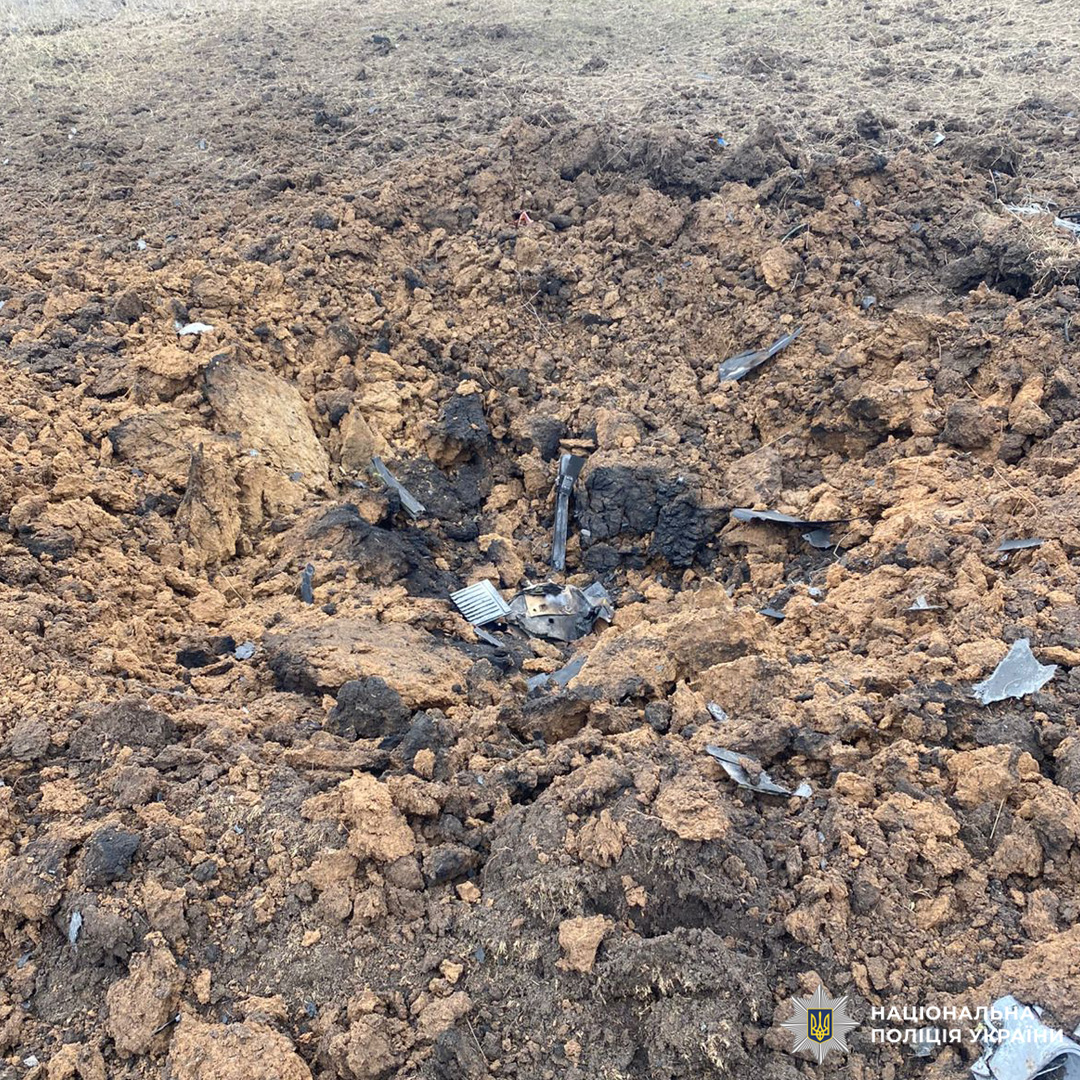 Велика вирва після вибуху, уламки навколо.