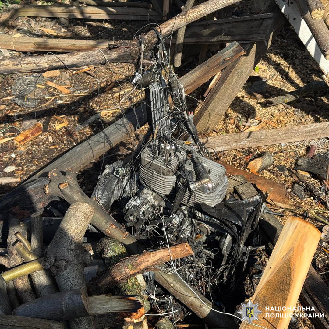 Пошкоджений двигун серед уламків деревини та кабелів, задокументований правоохоронцями.
