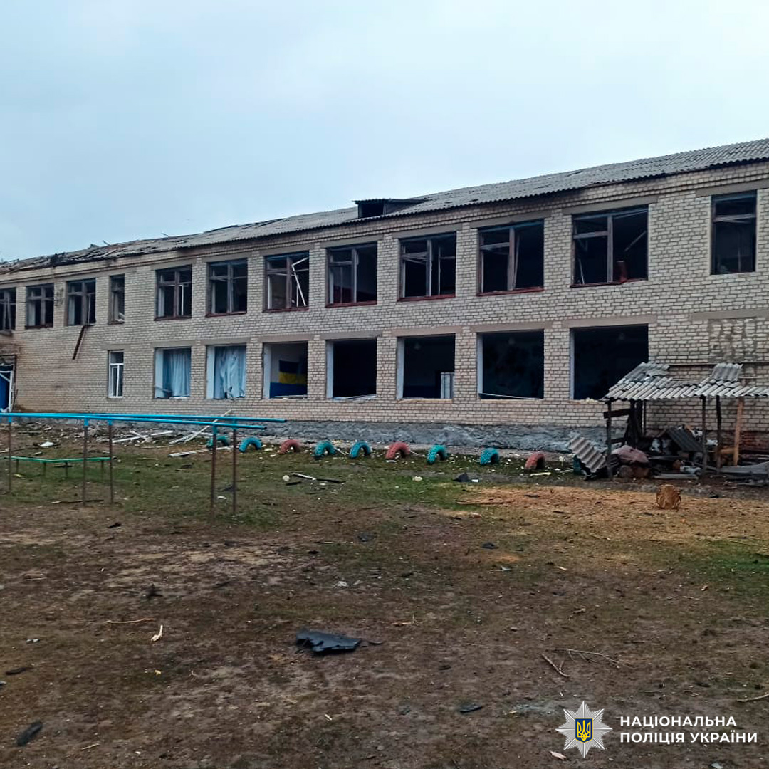 Зруйнована двоповерхова будівля з розбитими вікнами.