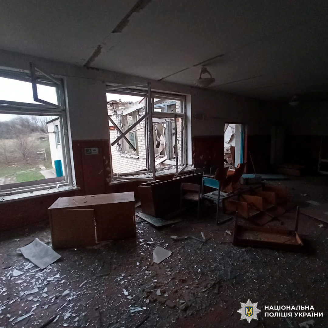 Зруйнований клас із розбитими вікнами та меблями.