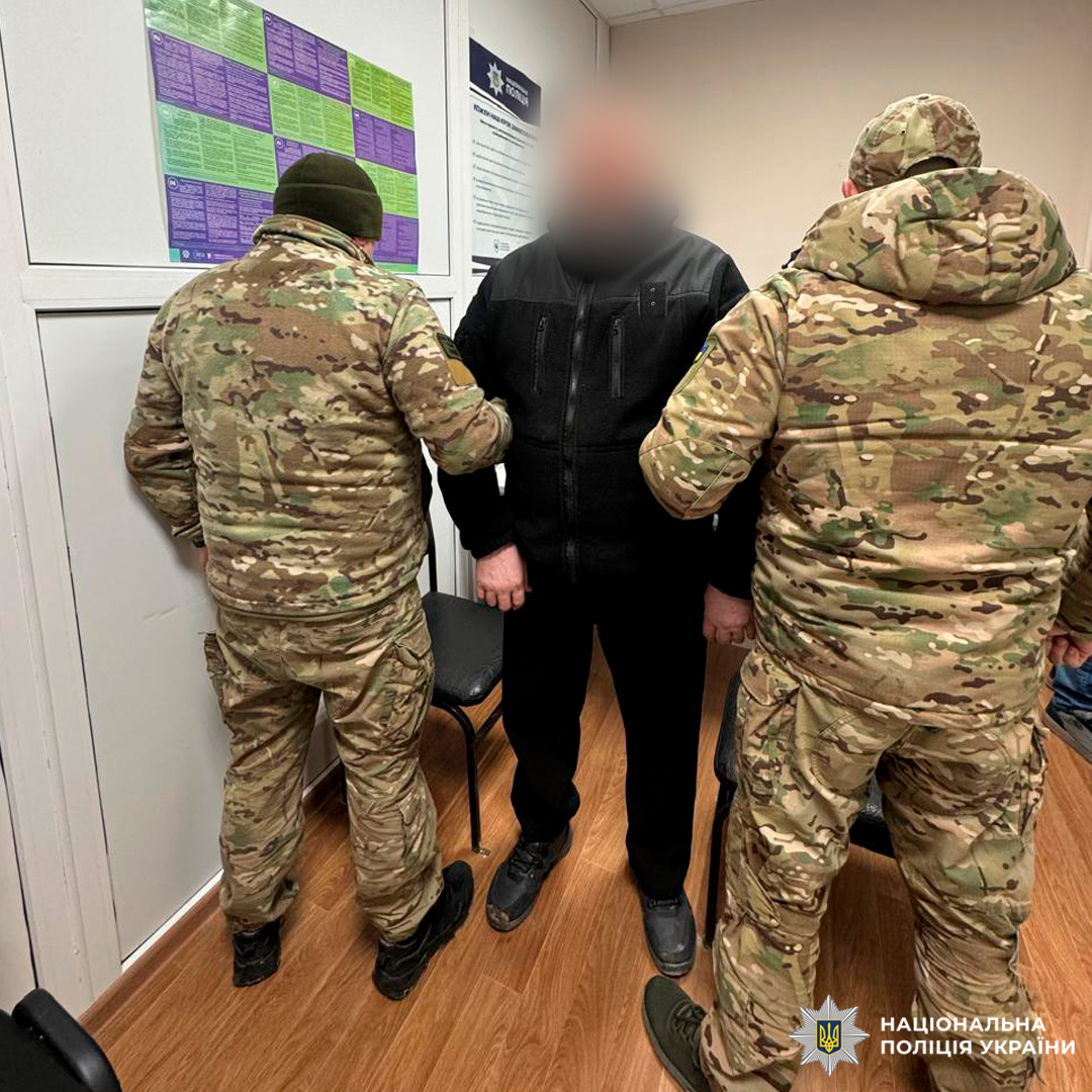 Поліцейські поруч із затриманим у приміщенні.