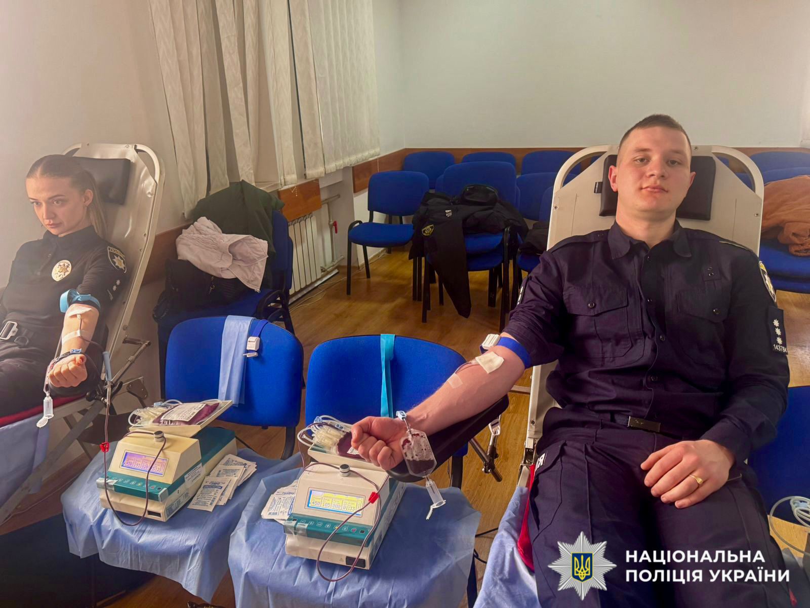 На фото зображено як поліцейський здає кров.