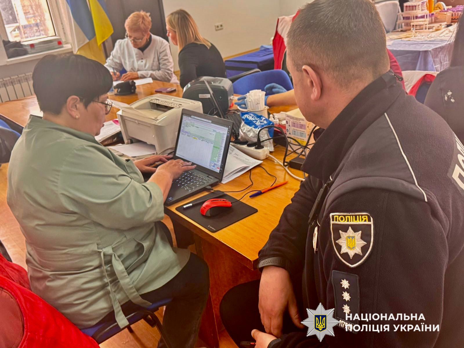 На фото зображено як поліцейський здає кров.