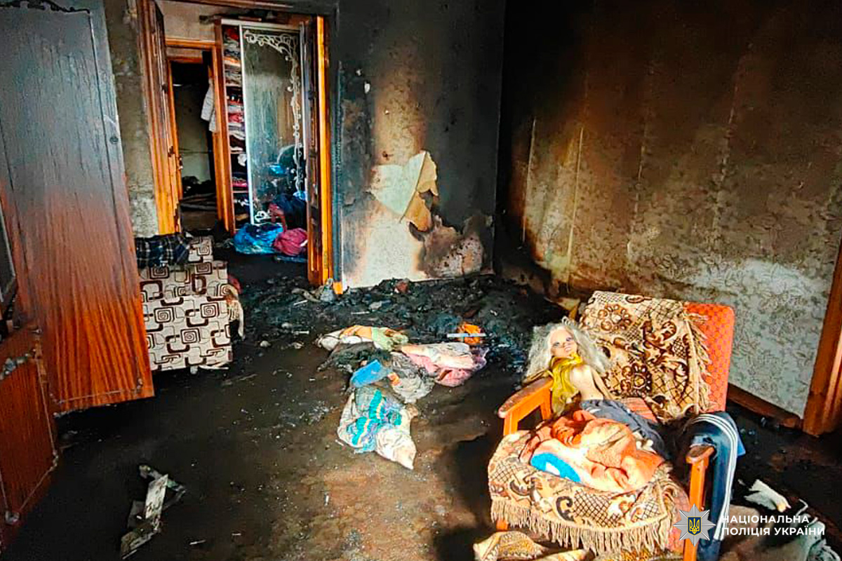 Зруйнована кімната після пожежі, обгорілі стіни та меблі.