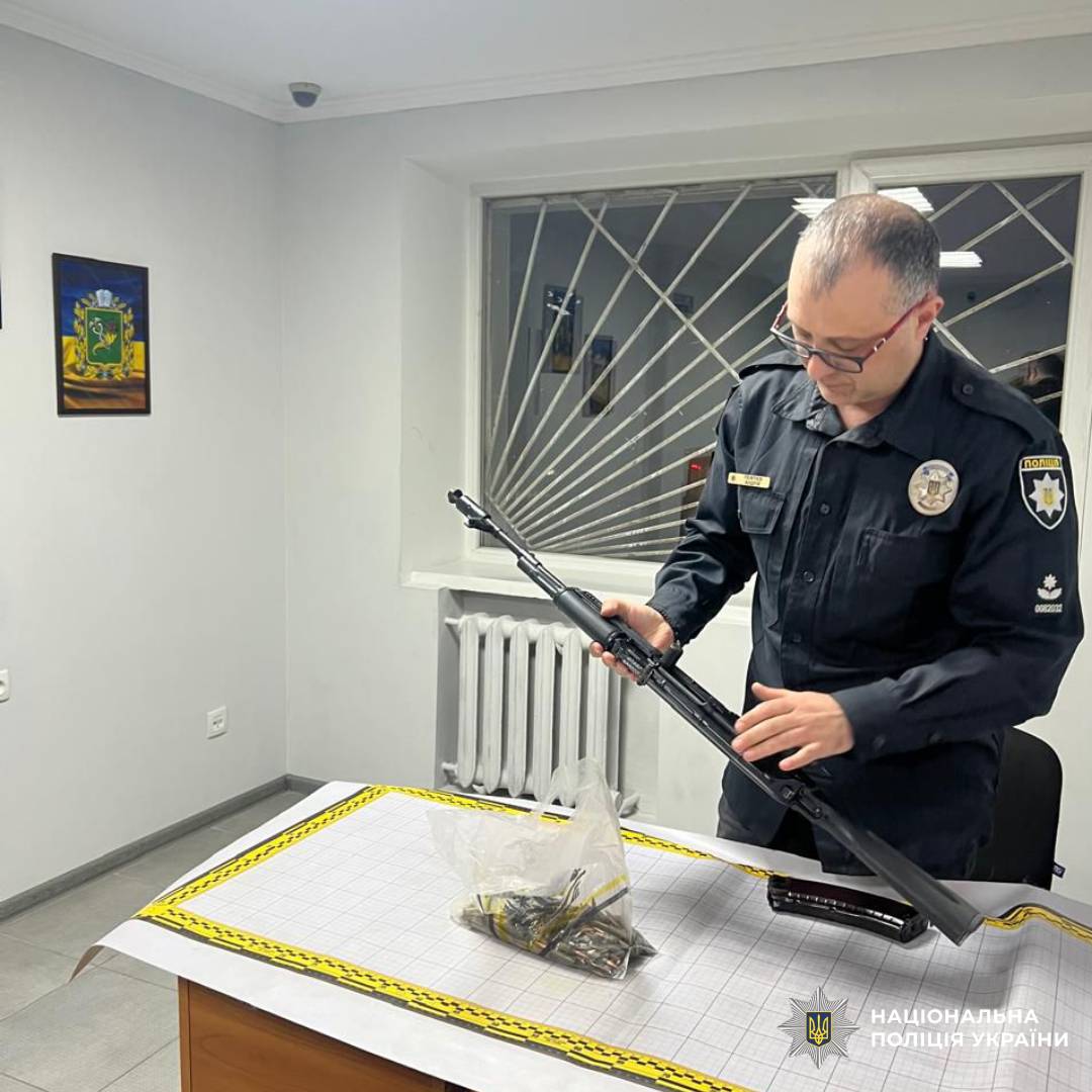 На фото зображений працівник поліції під час перевірки зброї