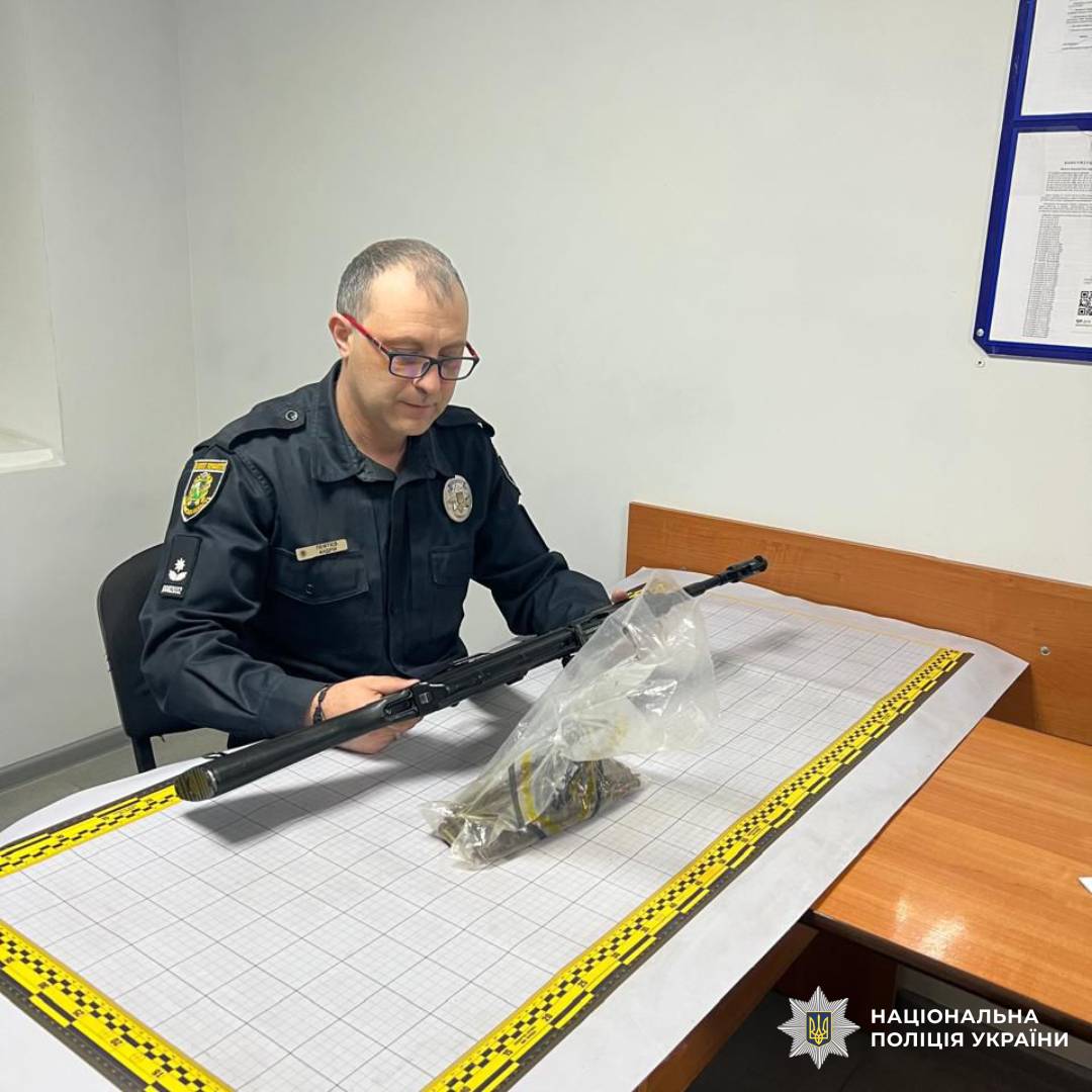 На фото зображений працівник поліції під час перевірки зброї