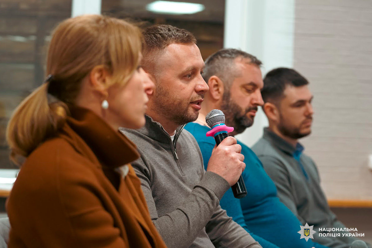 Група з чотирьох осіб, один говорить у мікрофон