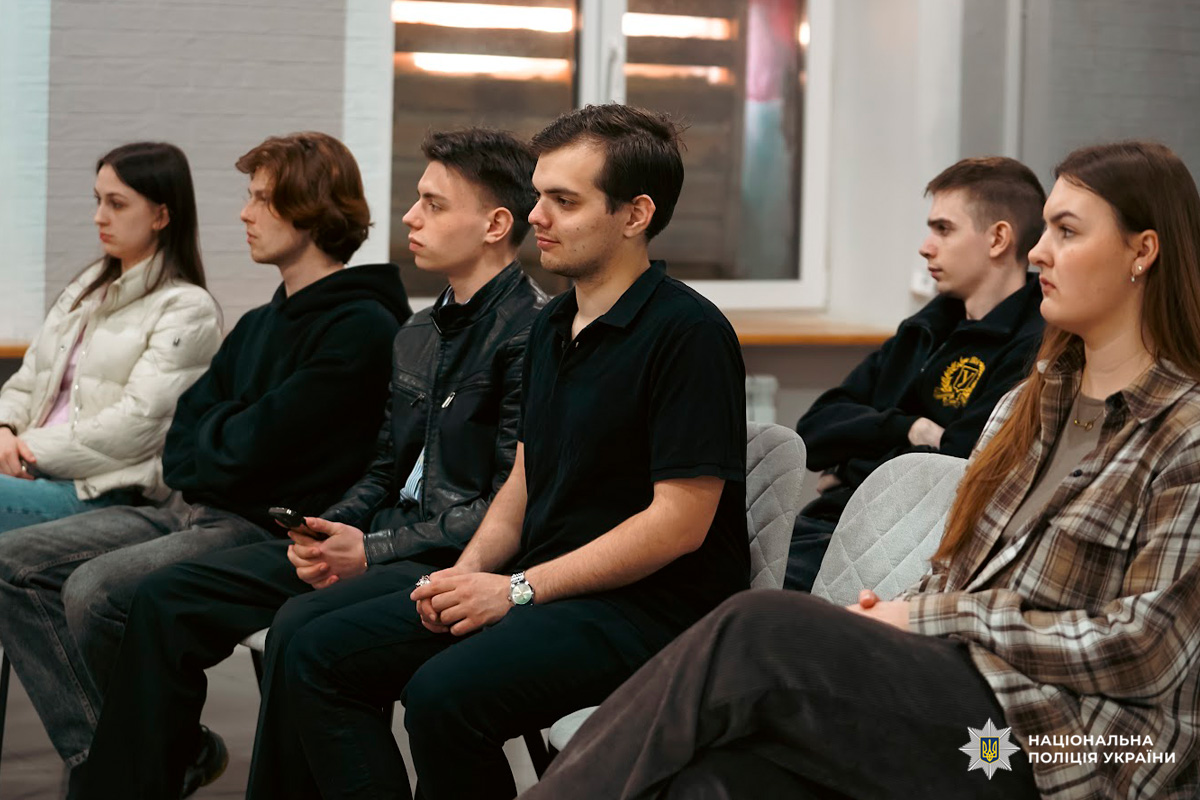 Шестеро молодих людей сидять на стільцях під час зустрічі