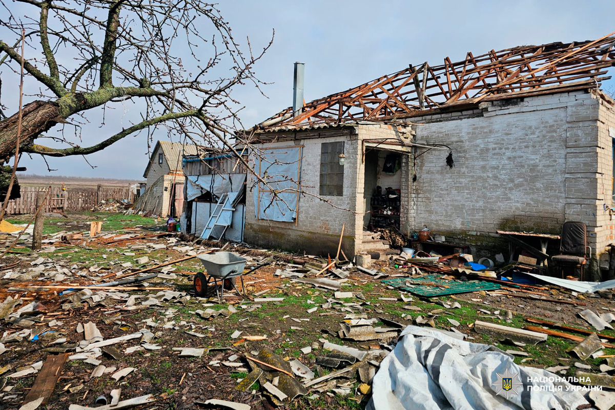Пошкоджений житловий будинок із частково зруйнованим дахом та розкиданими уламками.