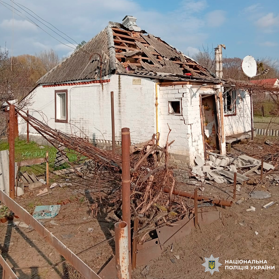 Білий цегляний будинок із частково зруйнованим дахом та пошкодженим фасадом.
