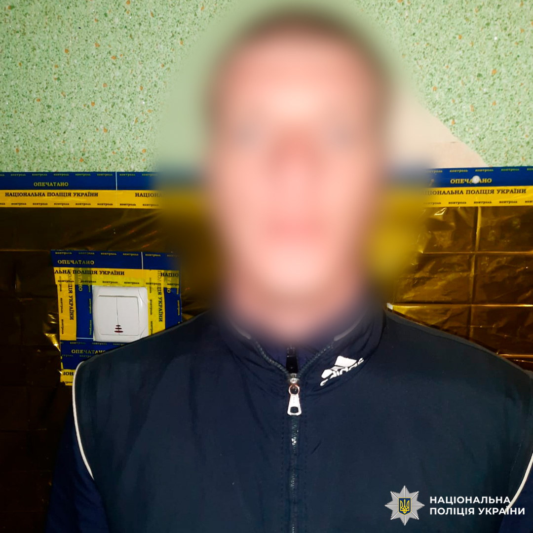 На фото людина біля стіни, частина якої опечатана стрічкою.