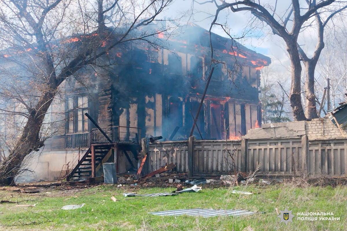 Двоповерхова будівля у вогні, дим здіймається над дахом.