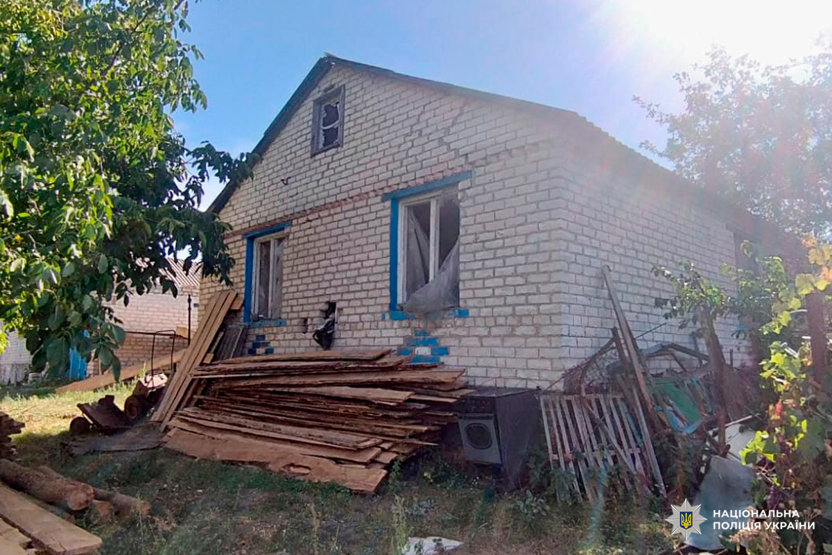 Білий цегляний будинок, пошкоджені вікна, уламки.