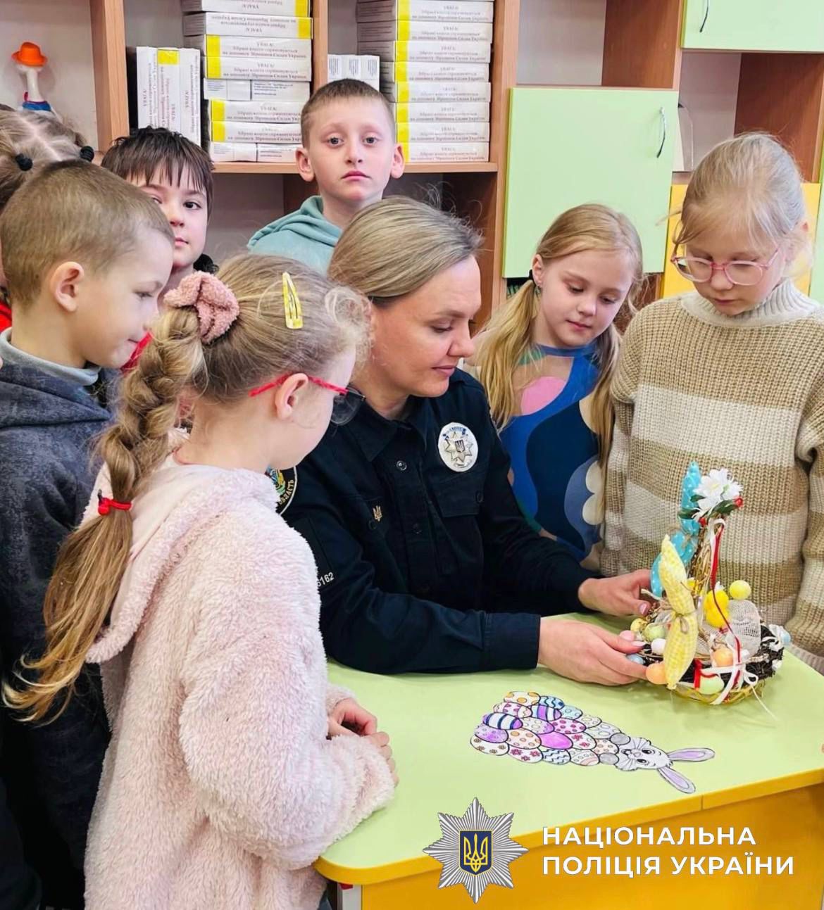 На фотографії зображено поліцейську та дітей, які у передвеликодні дні втілювали українські традиції та звичаї.