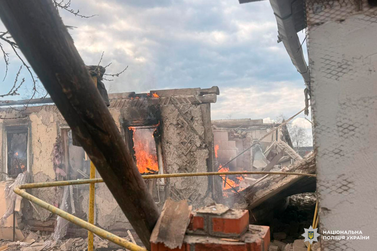 Палаюча будівля після вибуху: зруйновані стіни, уламки та пожежа всередині.