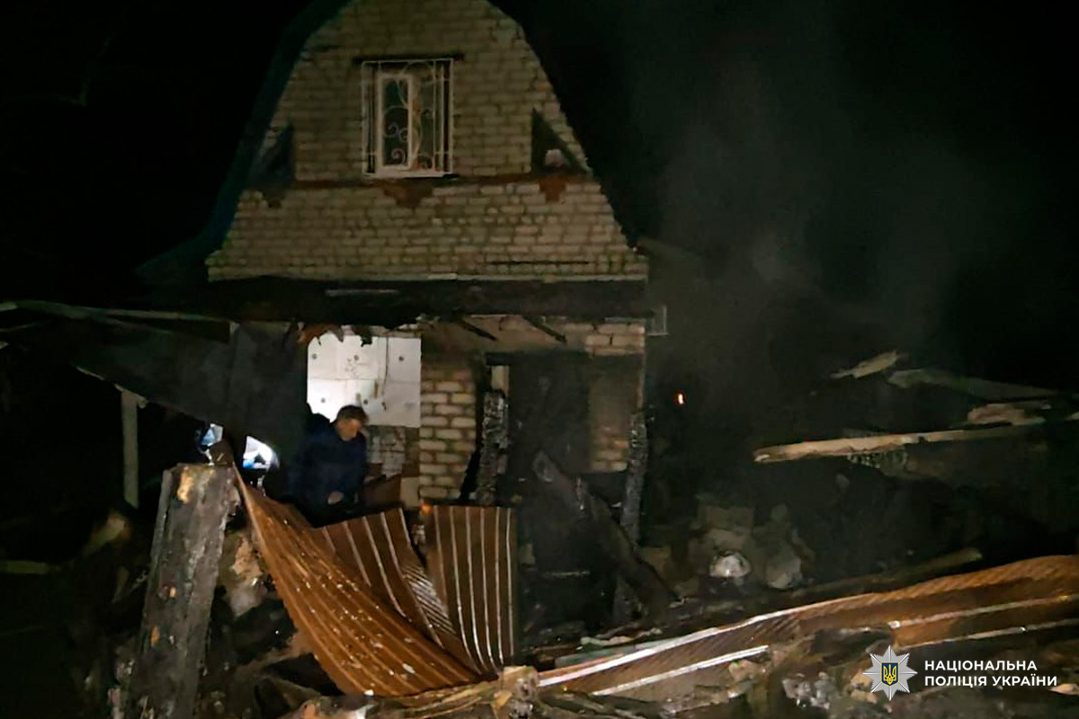 Цегляний будинок із серйозними пошкодженнями: дах обвалений, уламки та обгорілі матеріали розкидані навколо.