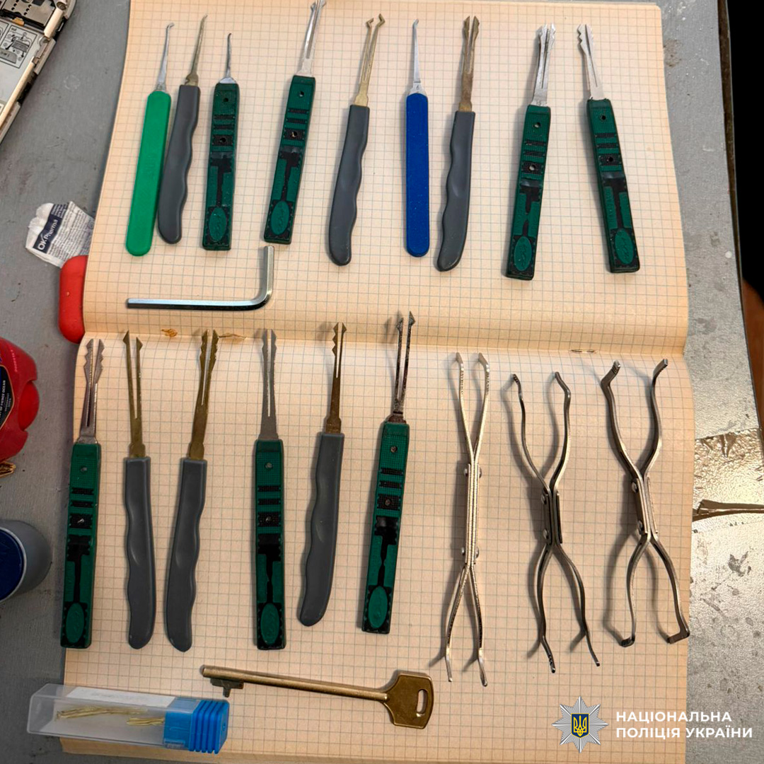 Набір інструментів для відмикання замків, розкладений на зошиті в клітинку.