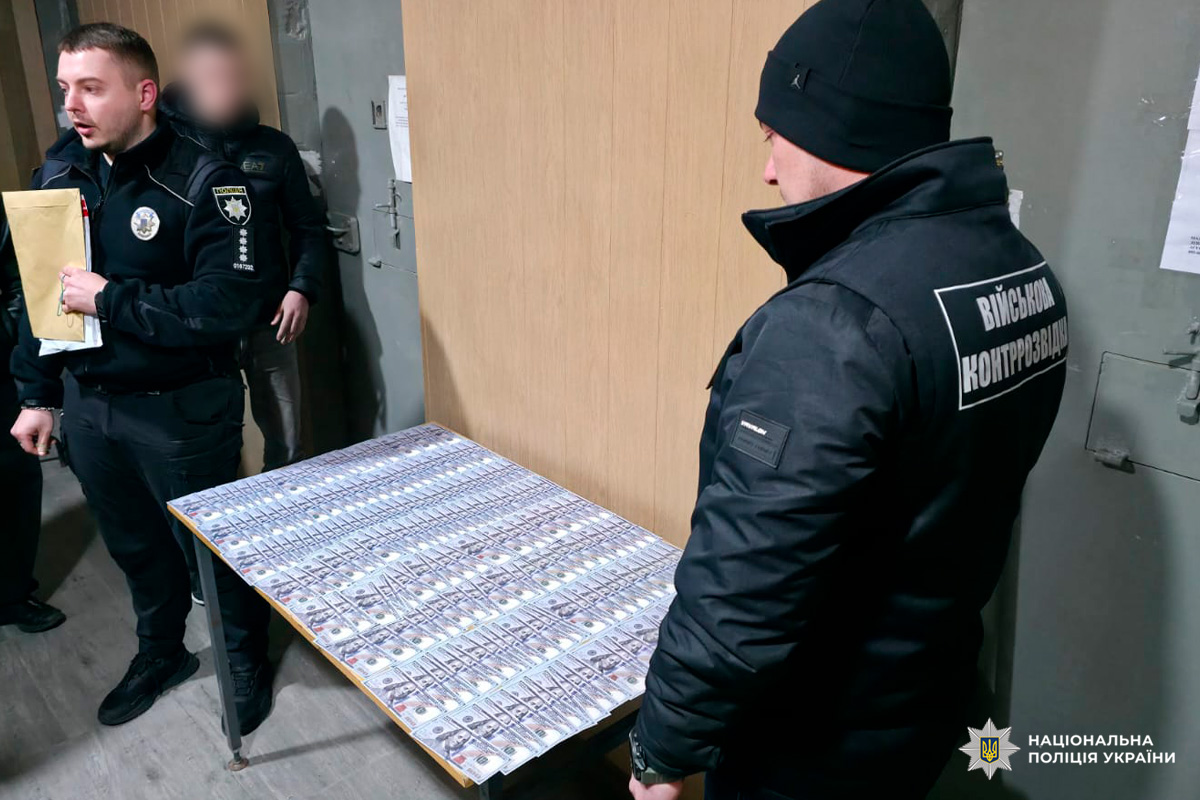 Правоохоронці документують вилучені кошти: купюри по 100 доларів США на столі.