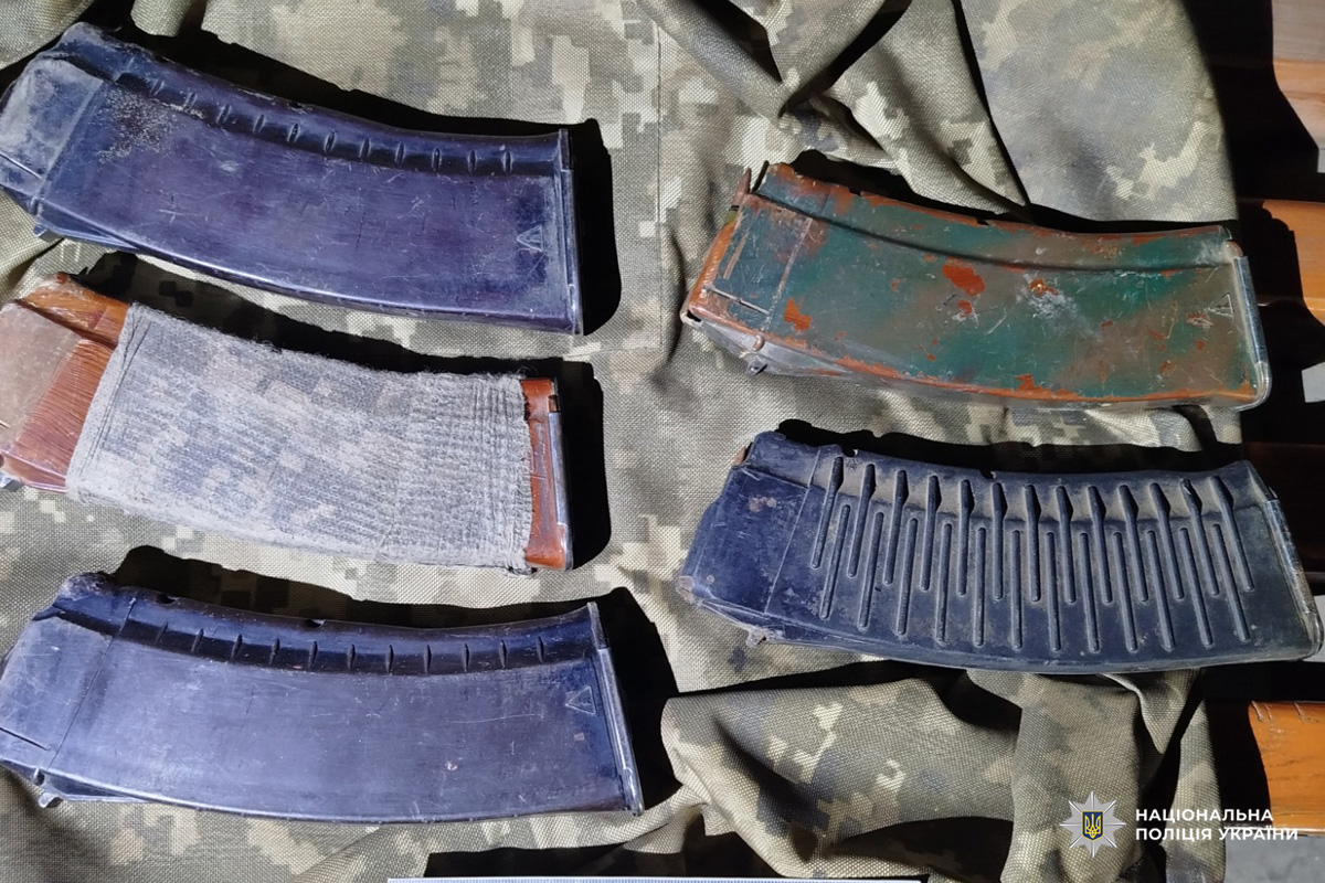 На камуфльованій тканині розкладені кілька магазинів до автоматичної зброї різного стану та типу — металеві й пластикові, деякі зі слідами зносу або пошкоджень. Один із них обгорнутий тканиною чи стрічкою.