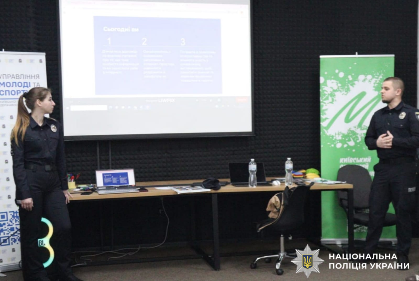 На фото правоохоронці біля екрану проектора.