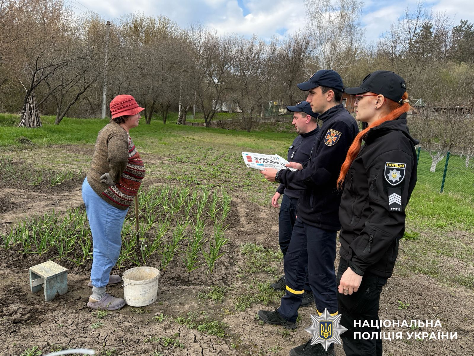 На фото поліцейська, працівники ДСНС та жінка.