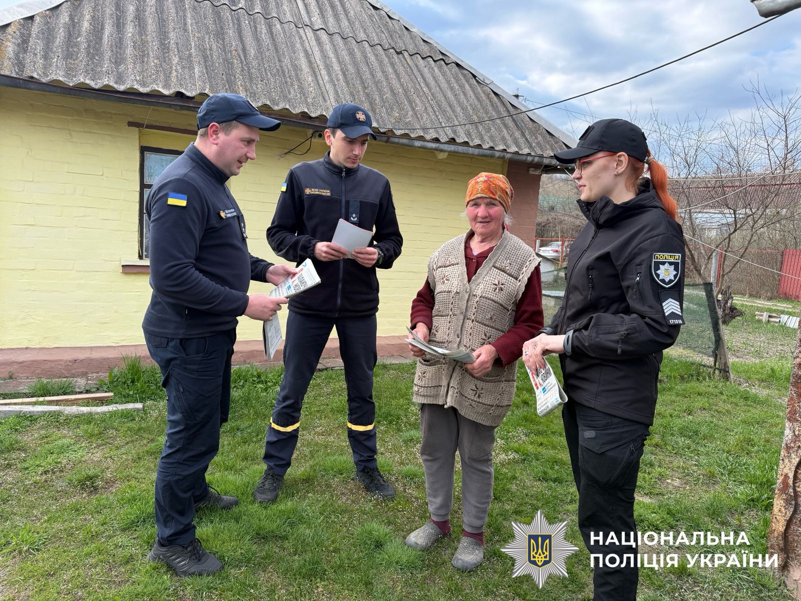 На фото поліцейська, працівники ДСНС та жінка.