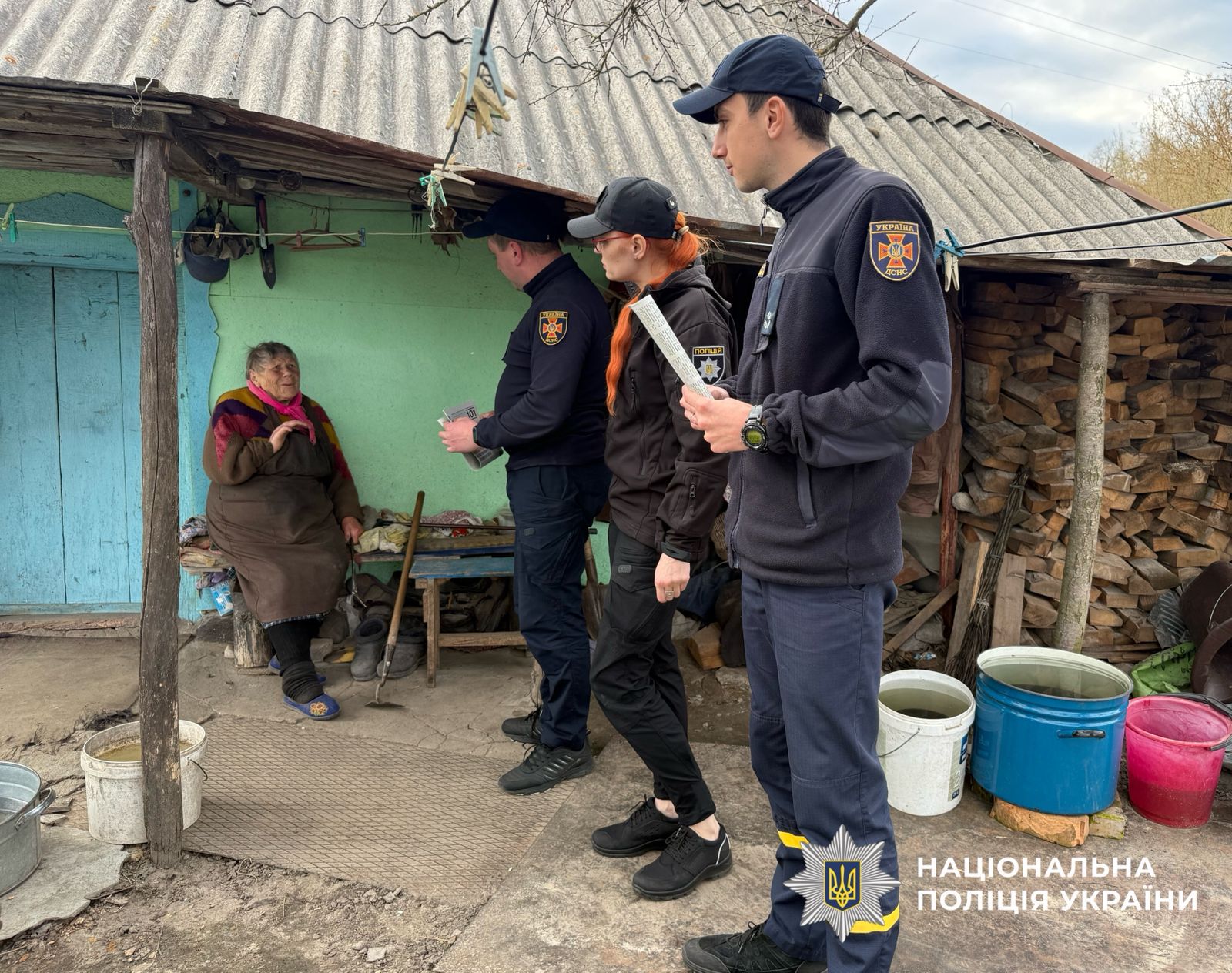 На фото поліцейська, працівники ДСНС та жінка.