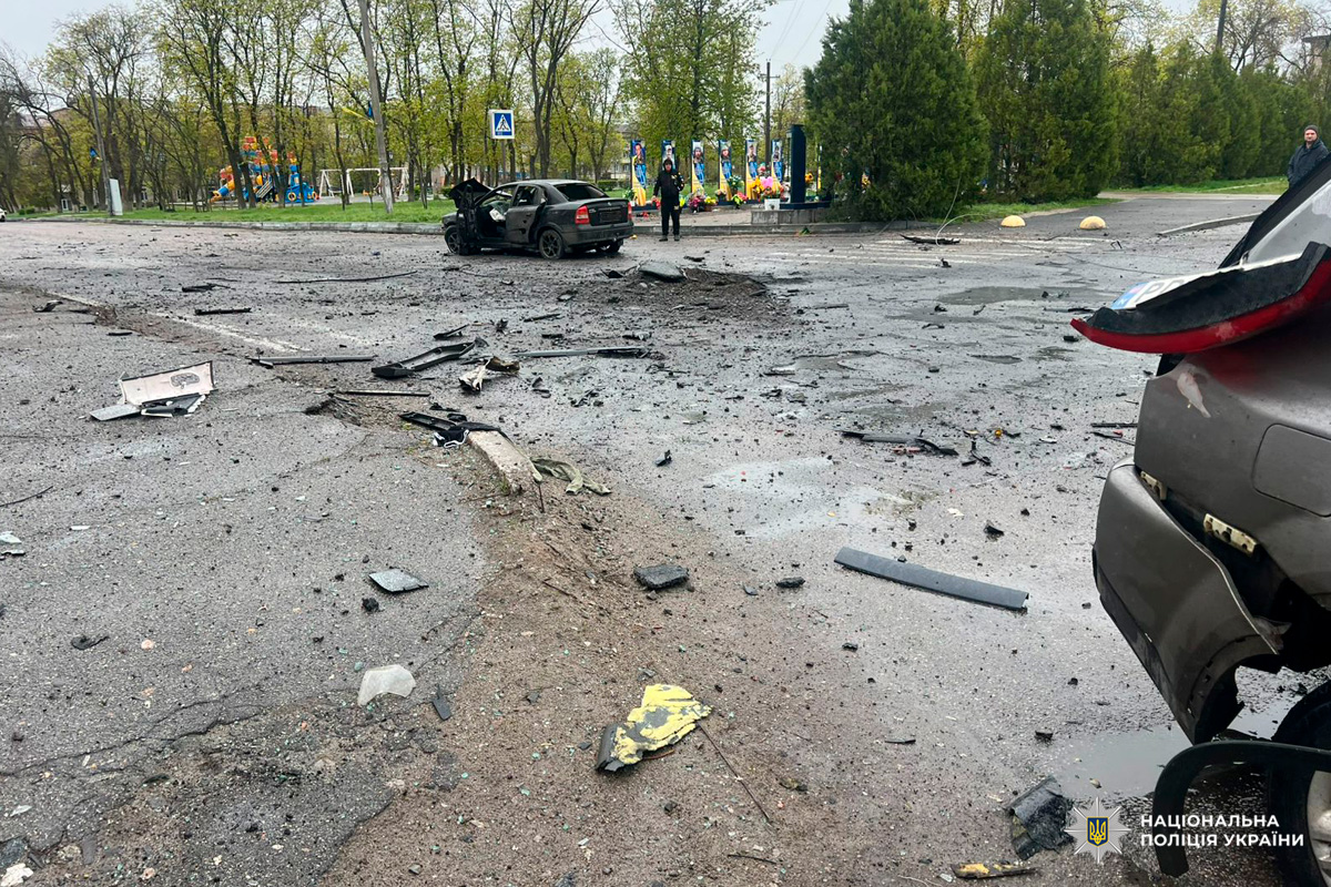 Пошкоджені автомобілі та уламки на міській вулиці після вибуху.