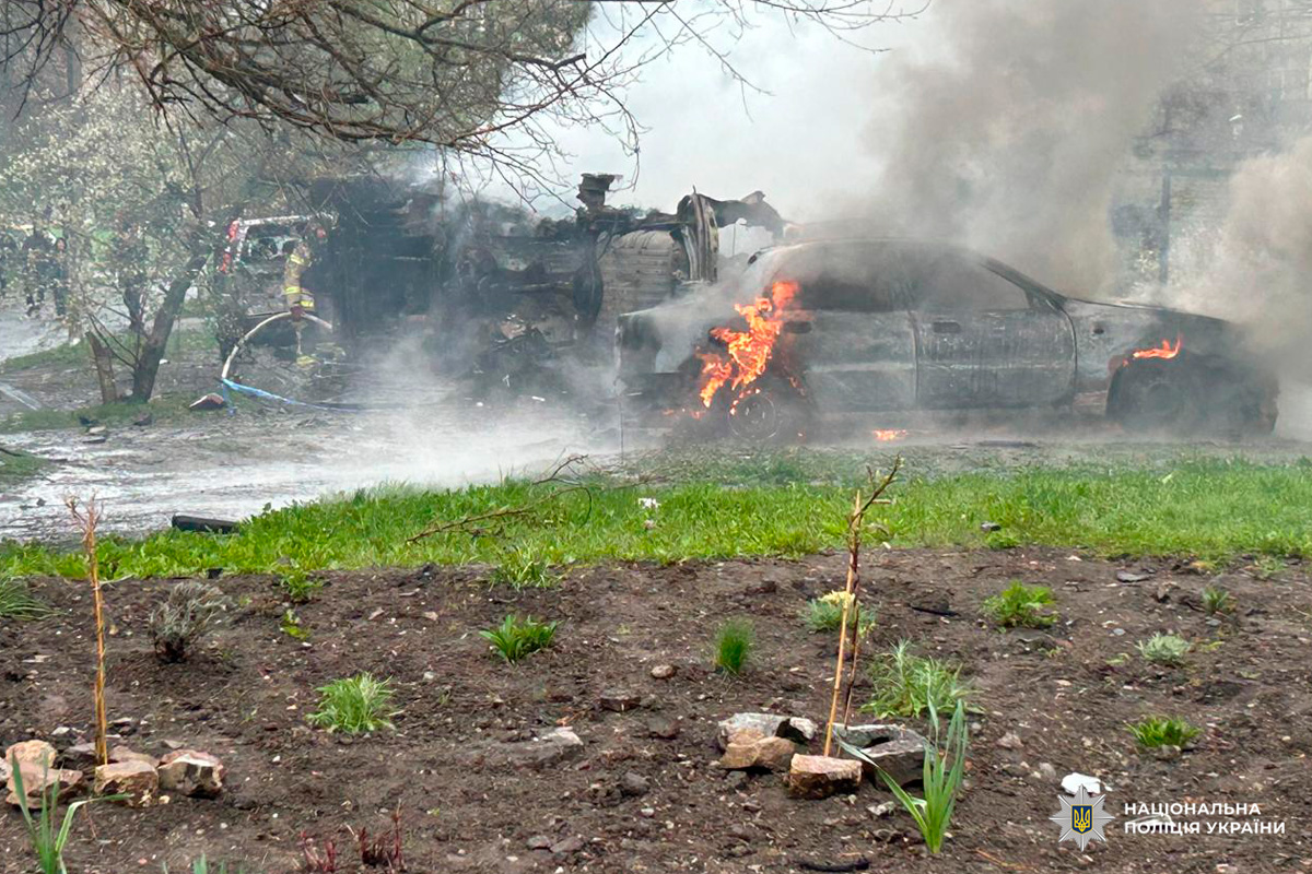 Пожежники ліквідують займання автомобіля, поруч перекинута машина.