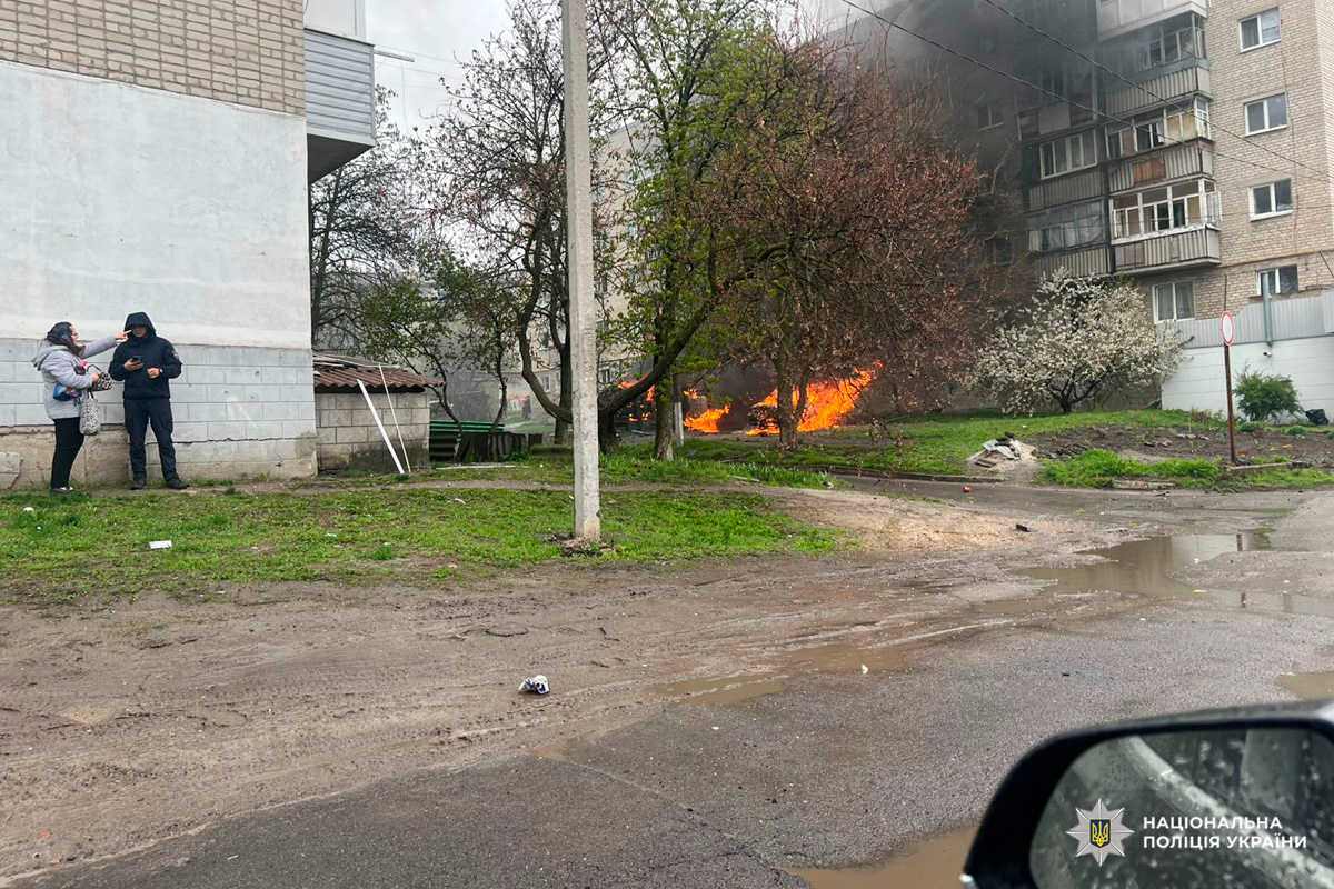 Пожежа серед дерев біля багатоповерхового будинку, густий чорний дим.