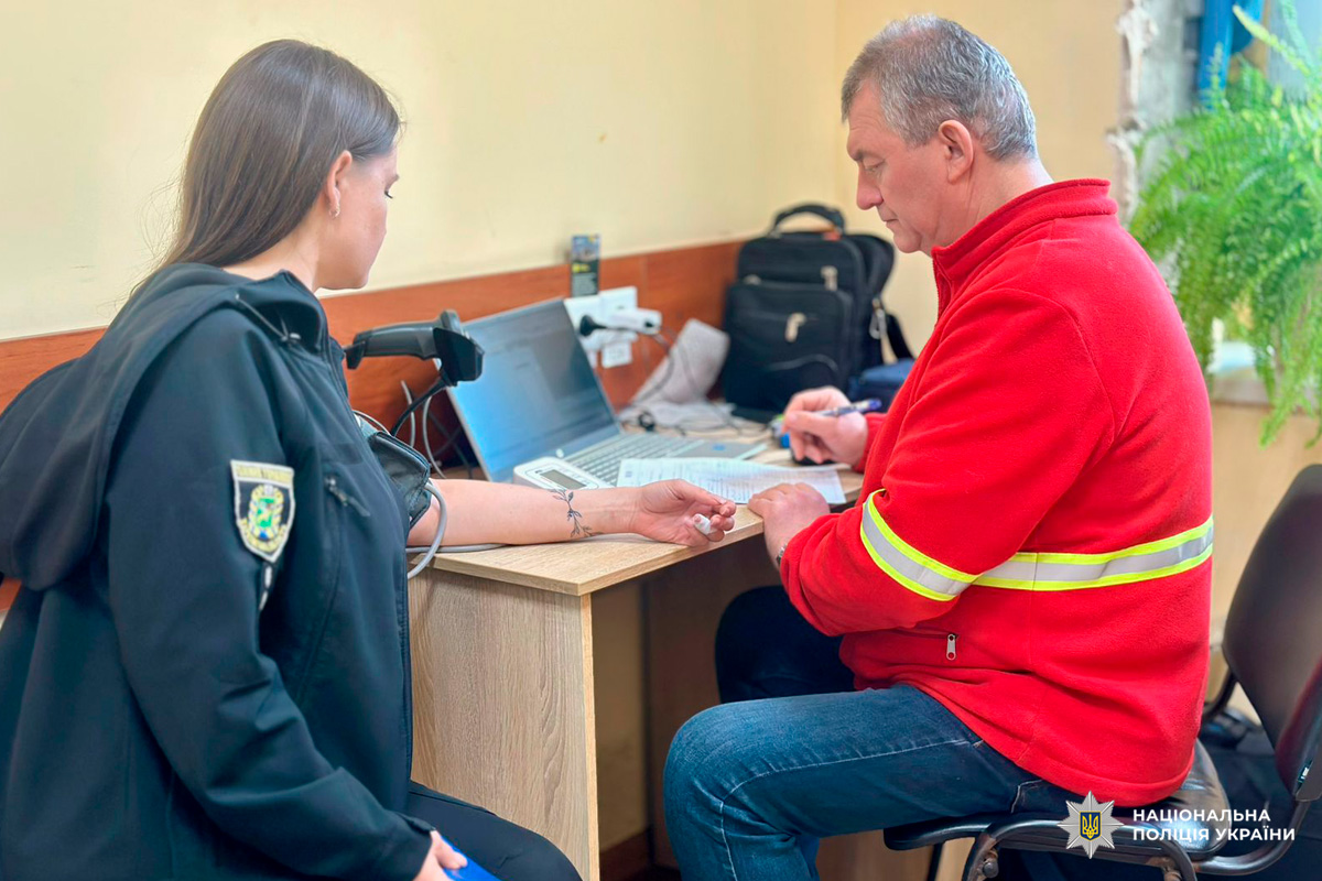 Поліцейський проходить медичну перевірку під час оформлення документів.