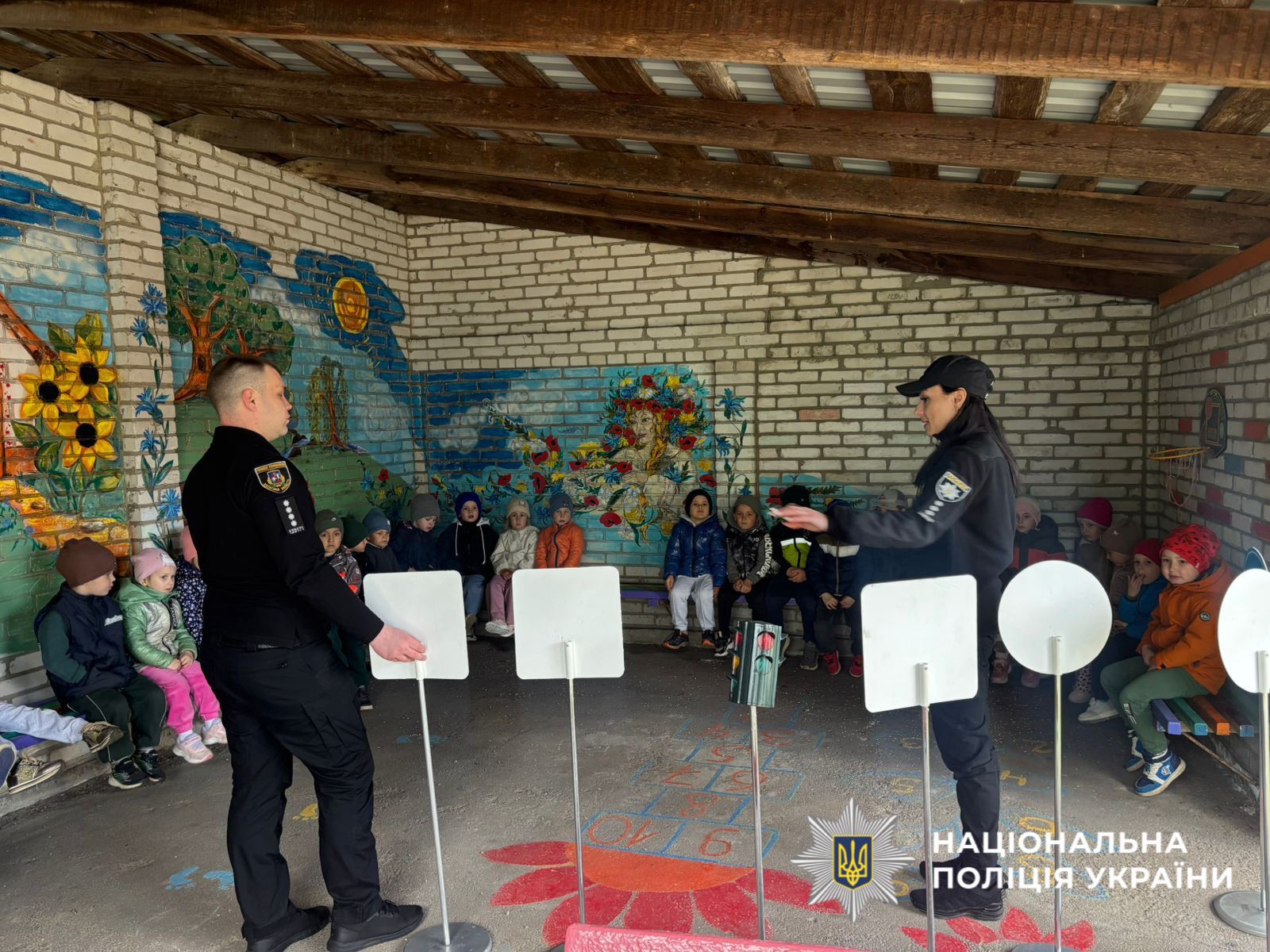 На фотографії зображено поліцейських Обухівщини, які організували для дітей інтерактивне заняття з безпеки.