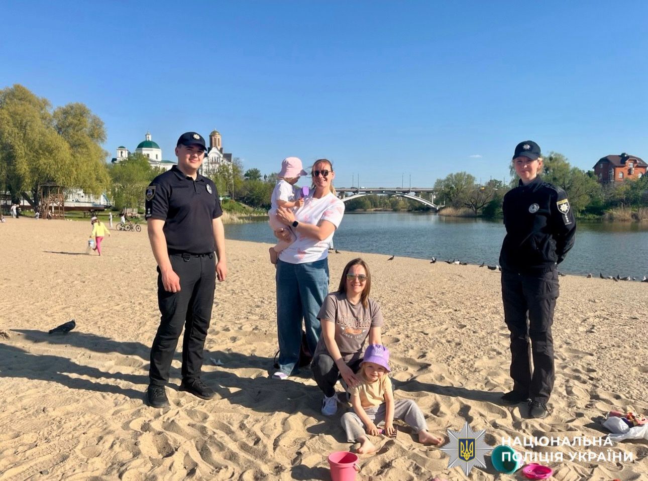 На фото зображені поліцейські разом з батьками та їх дітьми.