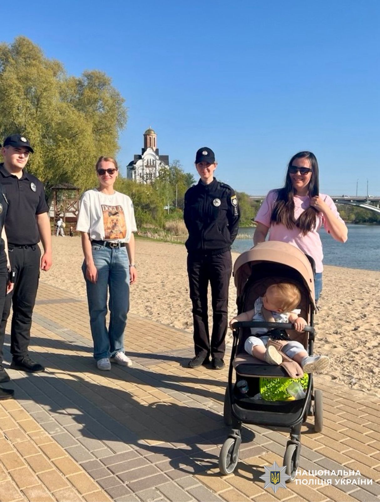 На фото зображені поліцейські разом з батьками та їх дітьми.