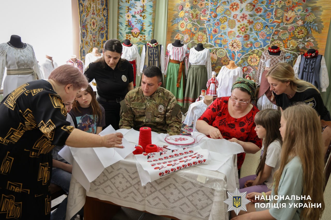 На фото зображені поліцейські та люди, які спільно вишивають
