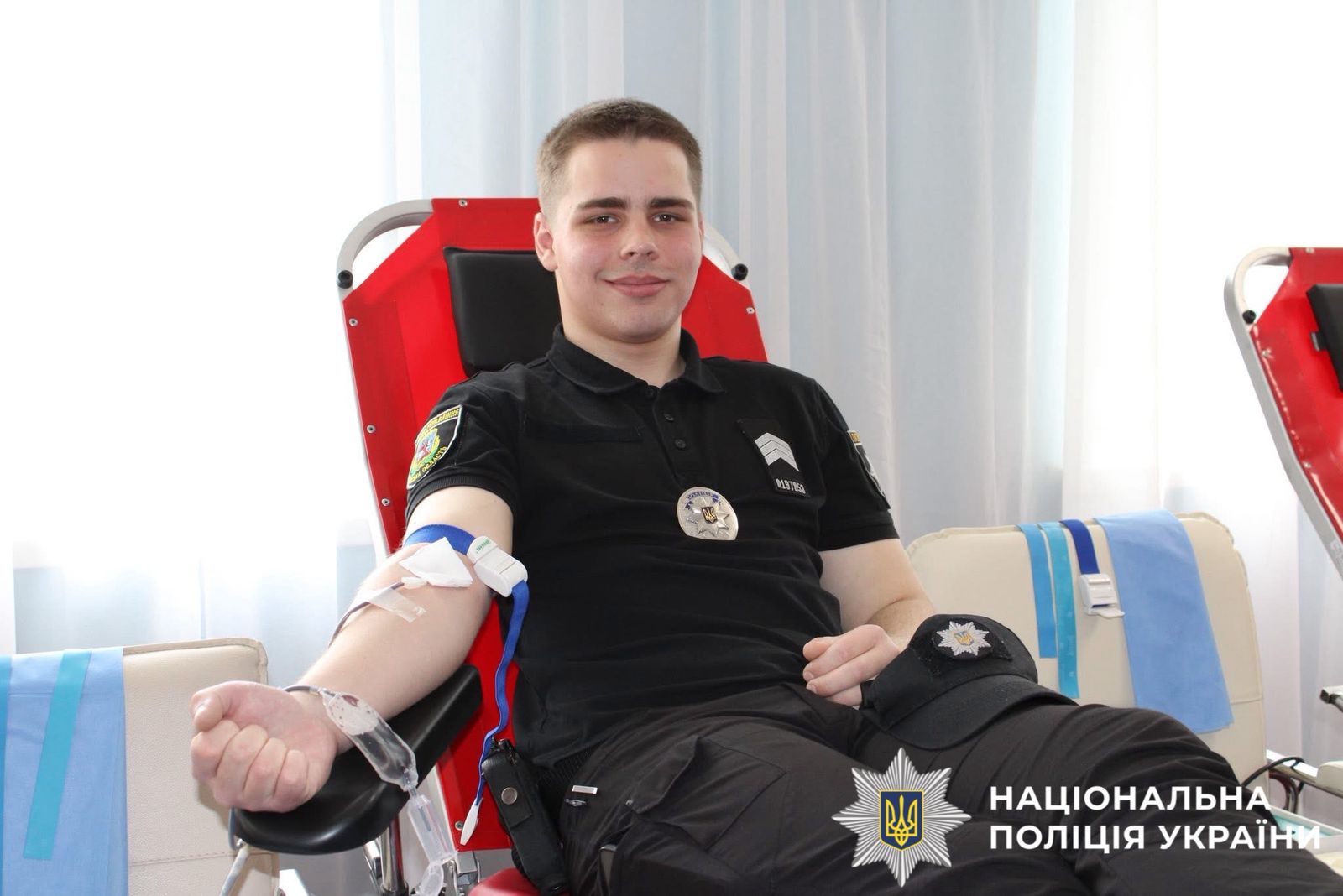 На фото зображено як поліцейський здає кров.