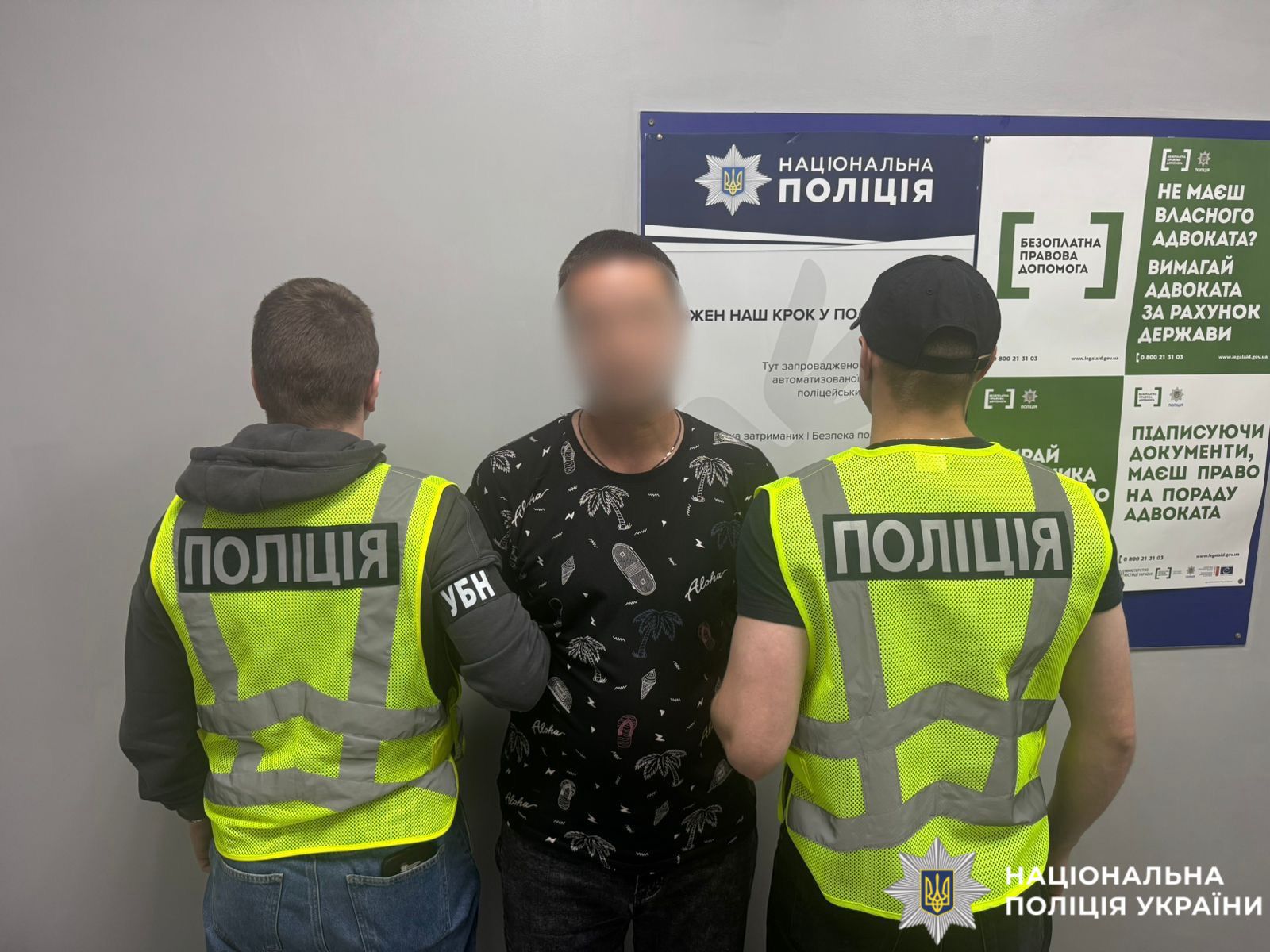 На фото затримана особа та працівники поліції.